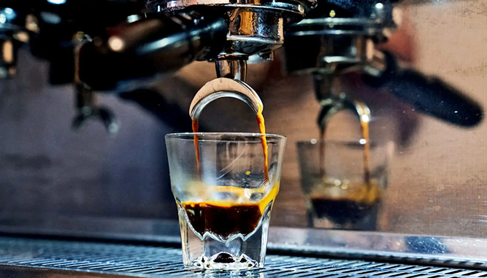 Espresso chảy vào ly từ máy pha cà phê