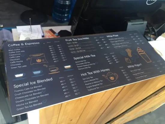 Alt text: Một không gian quán cà phê được thiết kế hiện đại, ấm cúng với bàn ghế gỗ và ánh sáng vàng